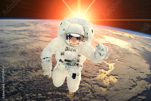 Fototapeta Naklejka Na Ścianę i Meble -  Astronaut and sunrise. The elements of this image furnished by NASA.