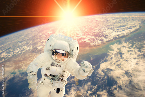 Fototapeta Naklejka Na Ścianę i Meble -  Astronaut and sunrise. The elements of this image furnished by NASA.