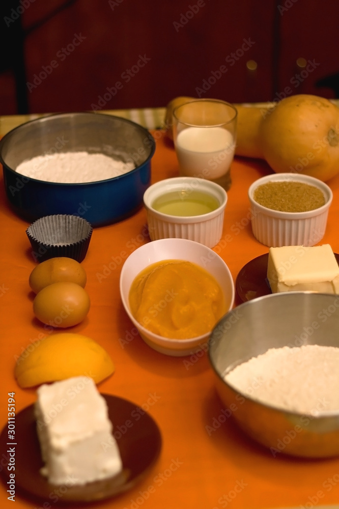 Cupcake ingredients on a table: pumpkin puree, flour, eggs, butter, sugar and nuts. Selective focus. Cupcake ingredients on a table: pumpkin puree, flour, eggs, butter, sugar and nuts. Selective focus.