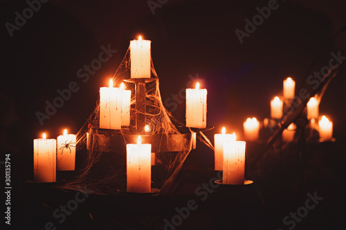 Canvastavla Candles burn in old chandelier in a dark basement