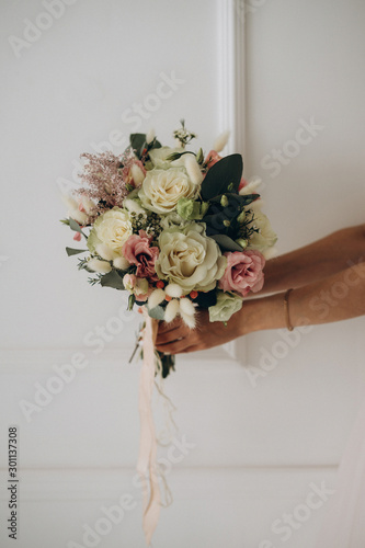 the bride’s bouquet in the bride’s hands, wedding details, selective focus, film and grain photo