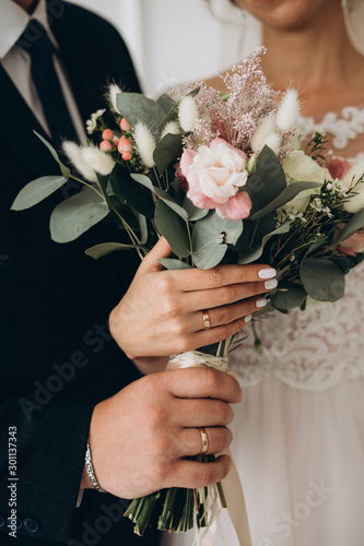 wedding bouquet in the hands of the bride and groom