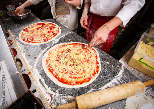 Two pizzas on the table, ready for bake photo