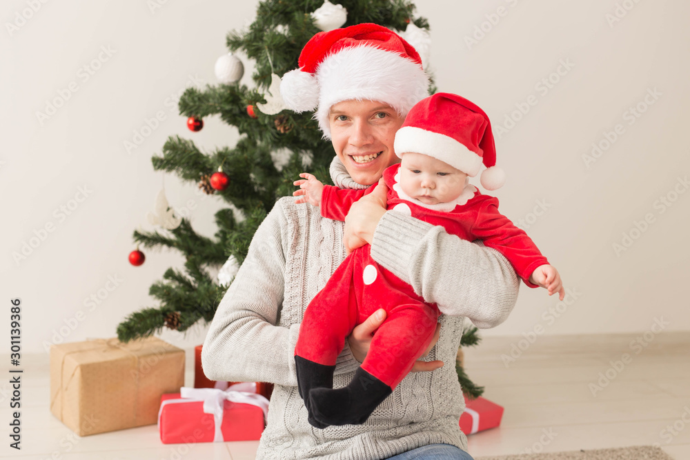Father with his baby boy wearing Santa hats celebrating Christmas. Father with his baby boy wearing Santa hats celebrating Christmas.