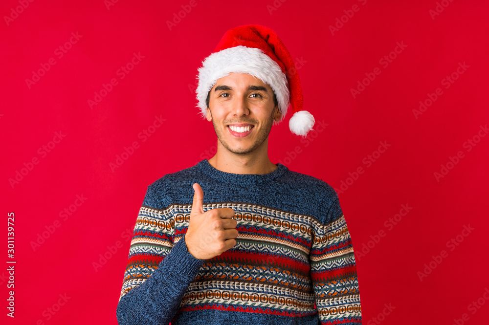 Young man on christmas day laughs out loudly keeping hand on chest. Young man on christmas day laughs out loudly keeping hand on chest.
