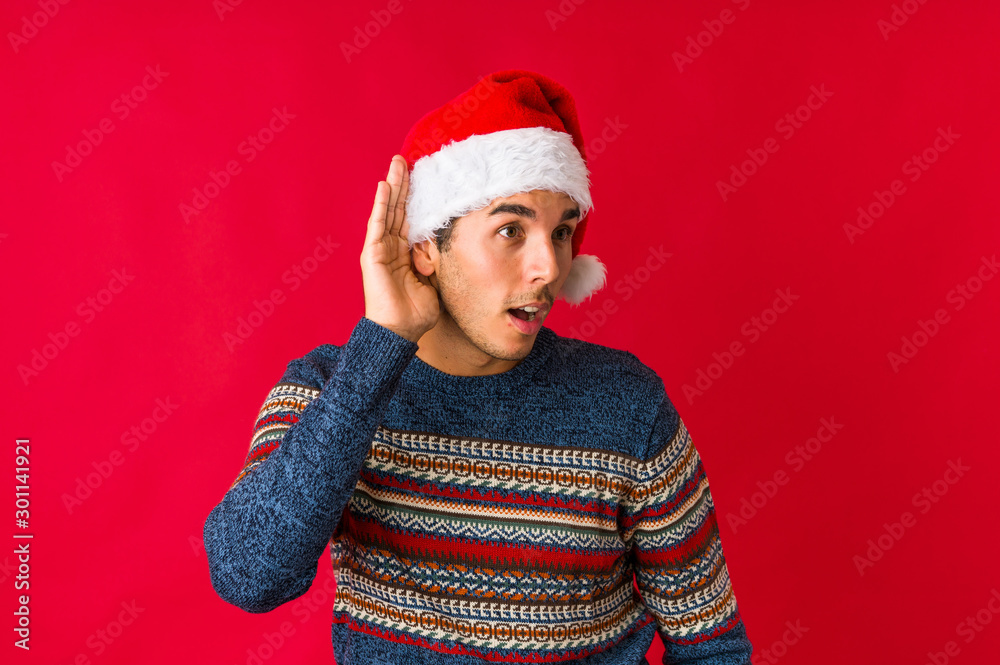 Young man on christmas day touching back of head, thinking and making a choice. Young man on christmas day touching back of head, thinking and making a choice.
