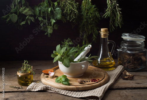 Fresh spices thyme, turmeric, cardamom, basil, mint, parsley, dill  and rosemary on wooden background.