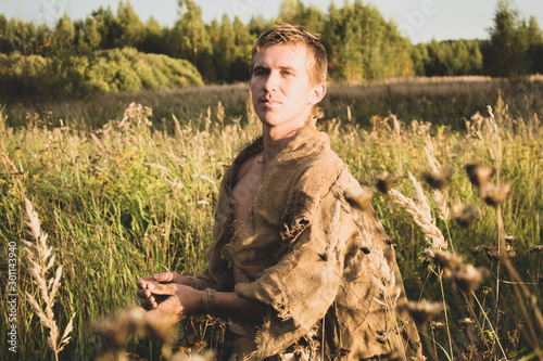 Downshifting concept - medieval peasant in a ragged clothes reconstruction