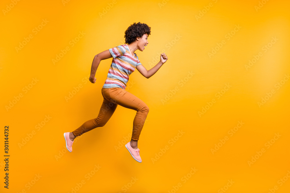 Full size profile photo of jumping high dark skin wavy lady speed race running competition participant wear casual clothes isolated bright yellow color background
