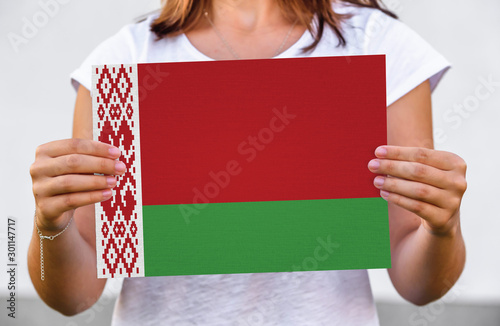 woman holds flag of Belarus on paper sheet