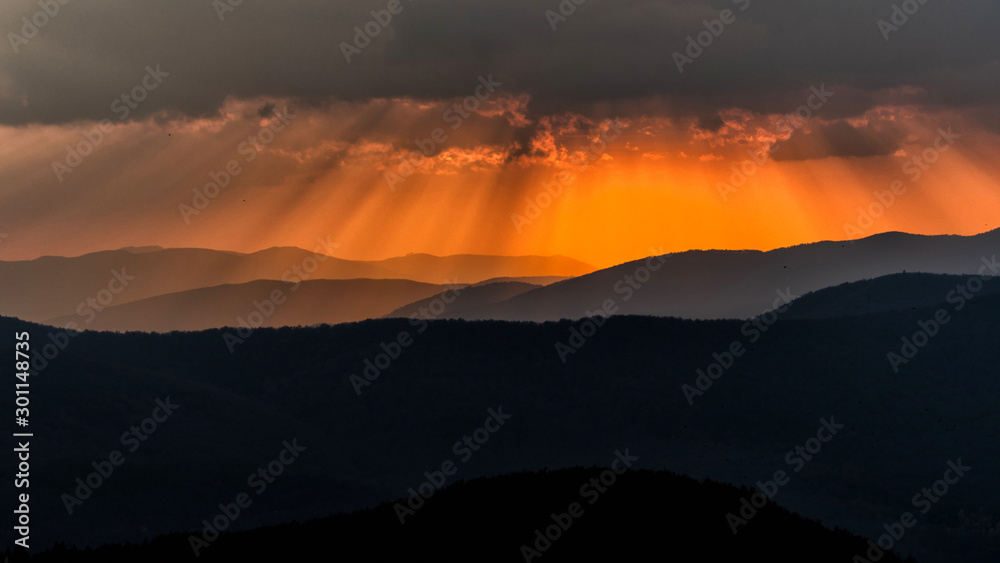 Mountains' silhouettes against the orange sky. Beautiful sunset in the Bieszczady Mountains. Poland