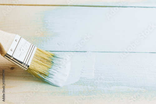 Paint brush with light blue paint on white background. Color of the Year 2020 - Bleached Coral. Renovation concept. Copy Space. Selective focus