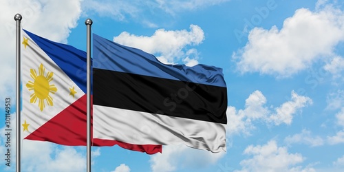 Philippines and Estonia flag waving in the wind against white cloudy blue sky together. Diplomacy concept, international relations.