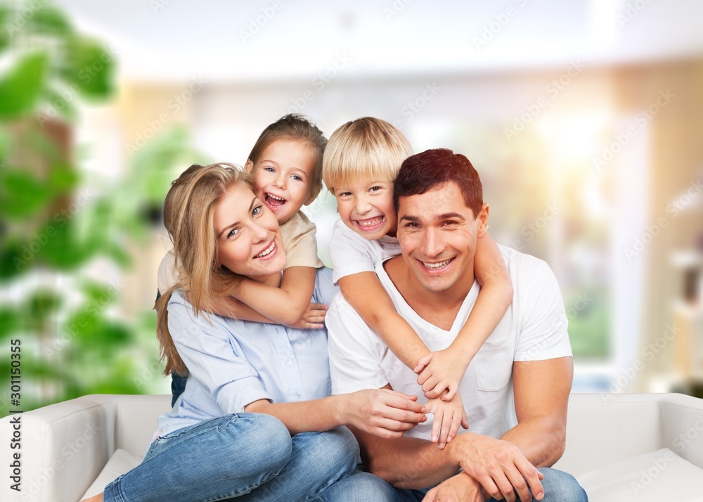 Beautiful smiling family sitting at sofa at home Beautiful smiling family sitting at sofa at home
