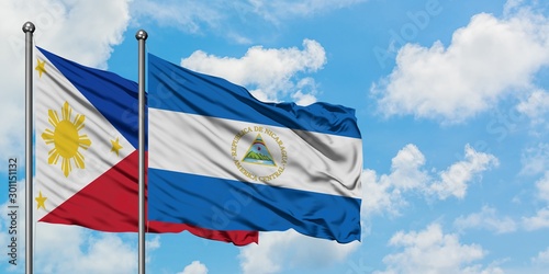 Philippines and Nicaragua flag waving in the wind against white cloudy blue sky together. Diplomacy concept, international relations.