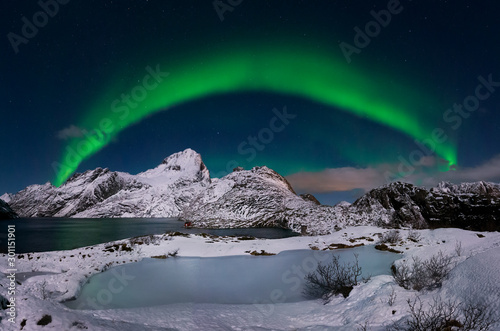 Aurora sobre lago en Lofoten Noruega