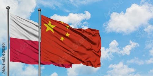 Wall Mural Poland and China flag waving in the wind against white cloudy blue sky together