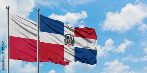 Poland and Dominican Republic flag waving in the wind against white cloudy blue sky together. Diplomacy concept, international relations.