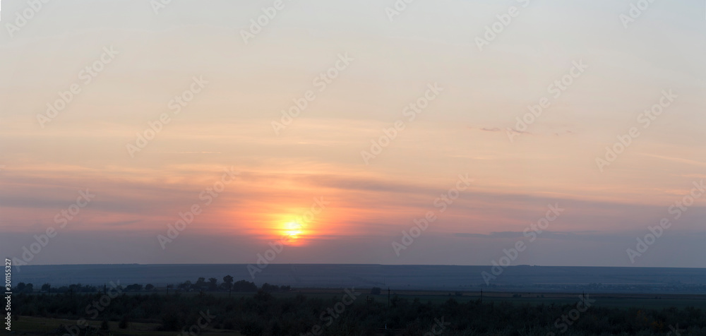 Landscape with bloody sunset. The terrain in southern Europe. Tragic gloomy sky. Purple-magenta clouds. Panorama.