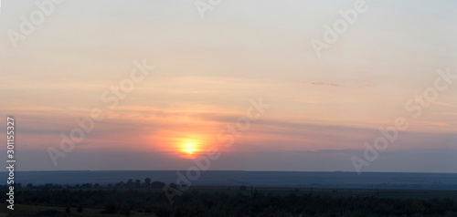 Landscape with bloody sunset. The terrain in southern Europe. Tragic gloomy sky. Purple-magenta clouds. Panorama.