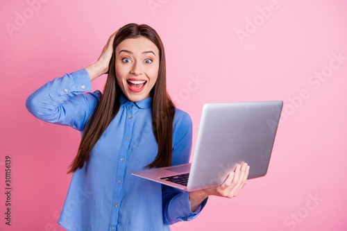 Photo of stylish trendy cute beautiful charming blogger having just won lottery and received notification into email wearing blue shirt isolated over pink color pastel background photo