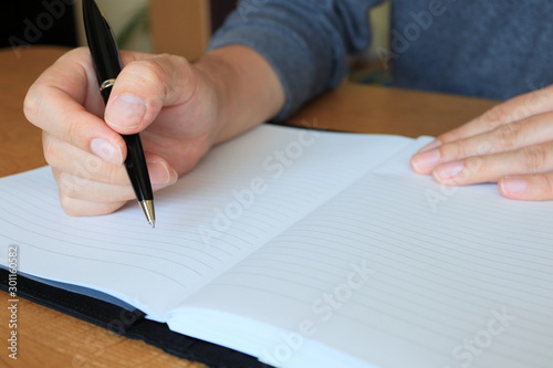 ノートにボールペンで書く手元のアップ