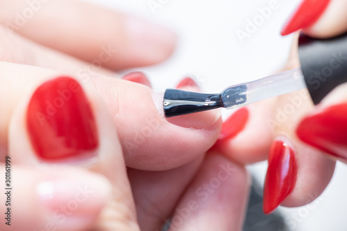 The process of professional manicure and preparation for applying gel polish. Macro photo of female fingers.
