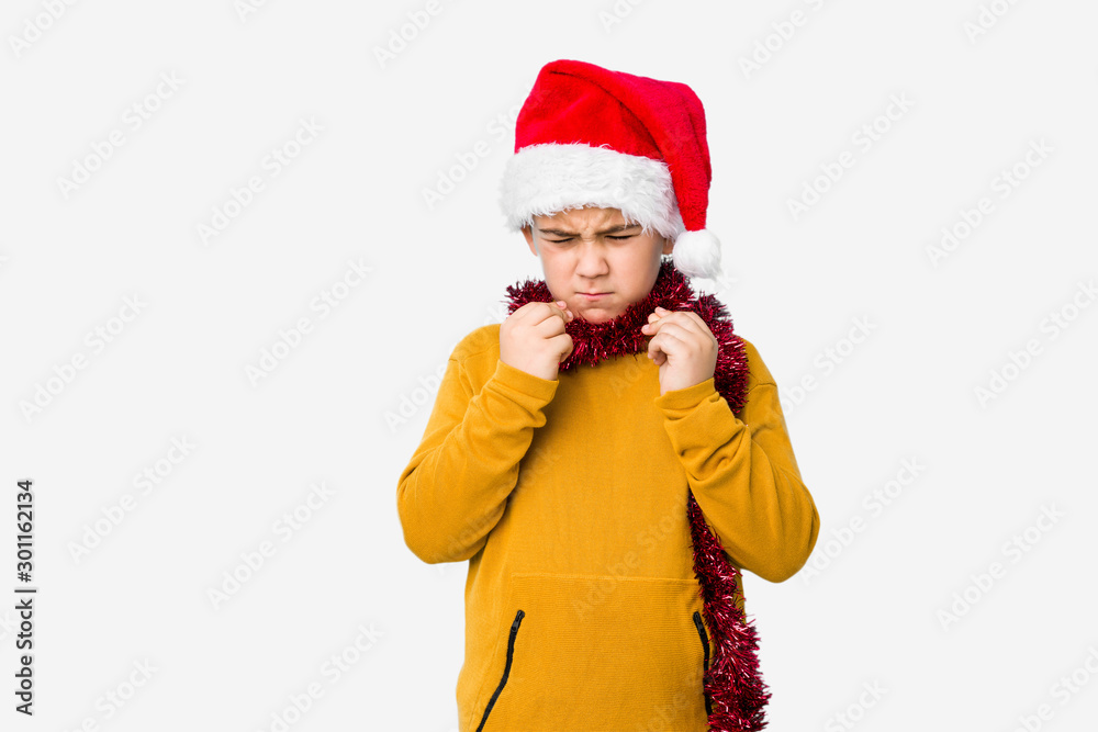 Little boy celebrating christmas day wearing a santa hat isolated showing that she has no money. Little boy celebrating christmas day wearing a santa hat isolated showing that she has no money.