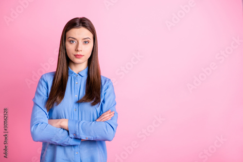 Photo of charming business lady with crossed arms not smiling wear blue dotted shirt with collar isolated pink color background © deagreez