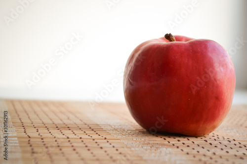 Red apple on a wooden mat