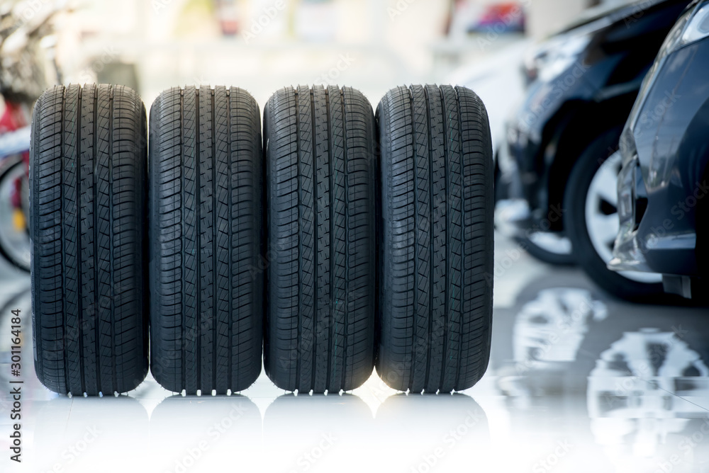 4 new tires that change tires in the auto repair service center, blurred background, the background is a new car in the stock blur for the industry, a four-wheeled tire set at a large warehouse 4 new tires that change tires in the auto repair service center, blurred background, the background is a new car in the stock blur for the industry, a four-wheeled tire set at a large warehouse