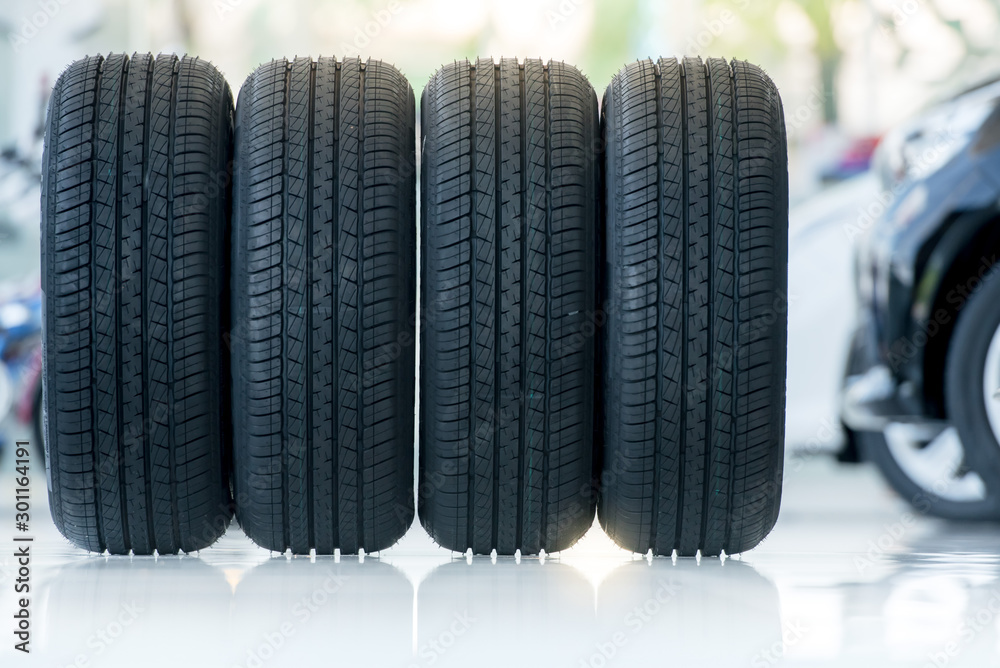 4 new tires that change tires in the auto repair service center, blurred background, the background is a new car in the stock blur for the industry, a four-wheeled tire set at a large warehouse 4 new tires that change tires in the auto repair service center, blurred background, the background is a new car in the stock blur for the industry, a four-wheeled tire set at a large warehouse