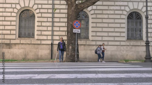 Blindness, autonomy, orientation.Blind young woman crossing the street with her stick photo