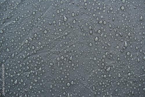 Wet grey surface of touristic tent. Drops of water