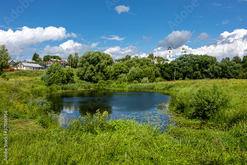 Russia, Vladimir Oblast, Golden Ring, Suzdal: Panorama with beautiful green natural landscape, calm lake pond of river Kamenka old onion domed church near center of one of the oldest Russian towns.