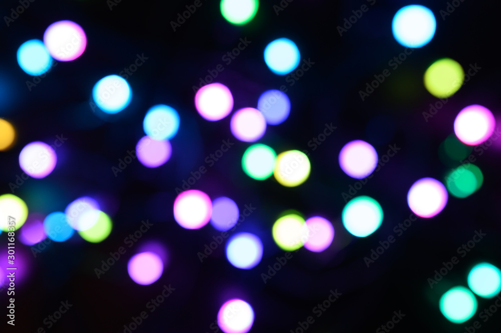 blurred night multicolored glowing lights on black background. new year and christmas concept