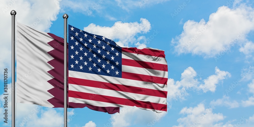 Qatar and United States flag waving in the wind against white cloudy blue sky together. Diplomacy concept, international relations. Qatar and United States flag waving in the wind against white cloudy blue sky together. Diplomacy concept, international relations.