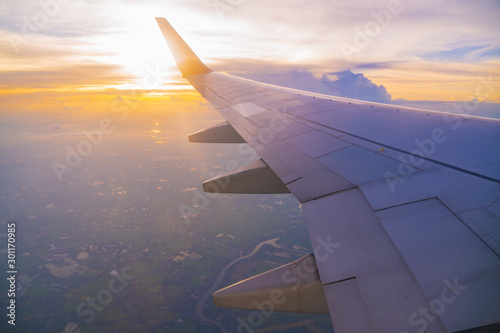 Beautiful sunset, sky on the top view, airplane flying view from inside window and cloud, sun down background aircraft of Traveling.