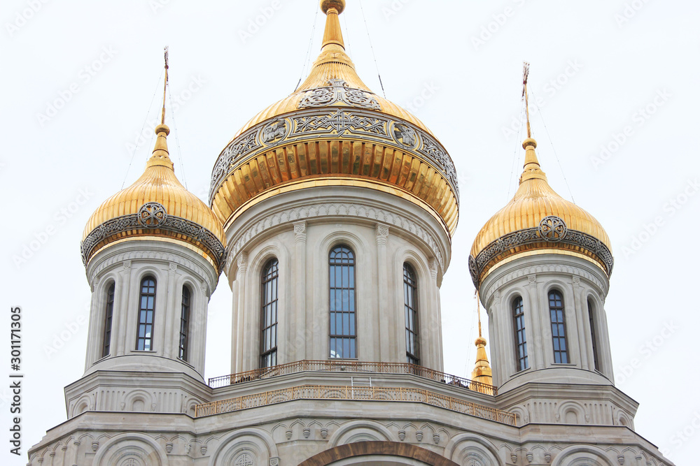 Russian orthodox church domes with golden cross. Religious symbols isolated on cloudy sky 