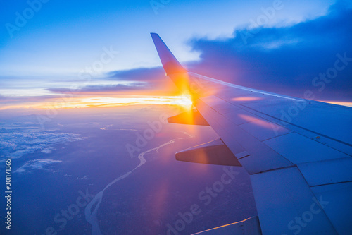 Beautiful sunset, sky on the top view, airplane flying view from inside window aircraft of Traveling.