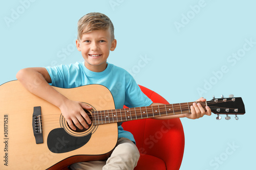 Little boy playing guitar o...