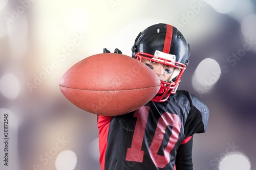 American football player with the ball isolated on a dark background