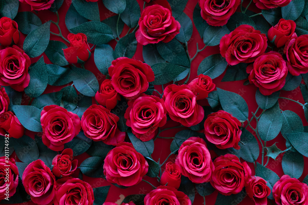 Artificial roses glued to the wall. Beautiful background of their bright red flowers Artificial roses glued to the wall. Beautiful background of their bright red flowers