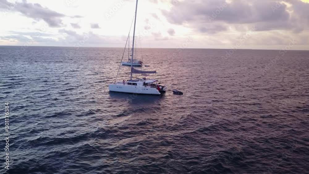 Sailboats in the ocean as the sun rises up, dramatic Drone helix around boats Sailboats in the ocean as the sun rises up, dramatic Drone helix around boats
