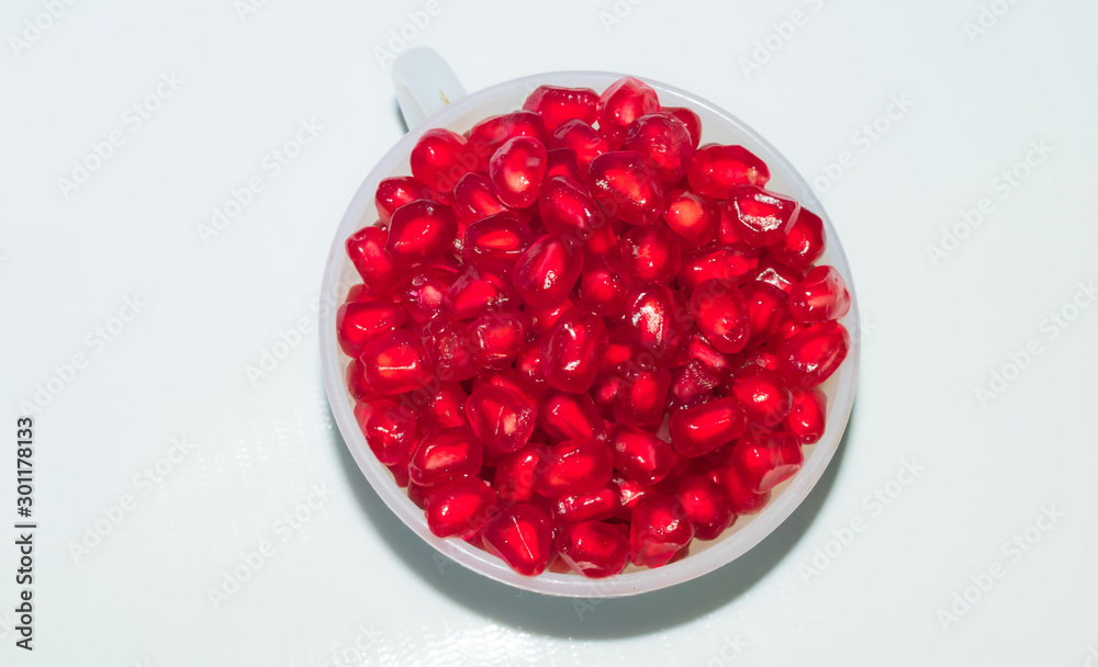 close up of fresh tasty red pomegranate seeds in a white cup close up of fresh tasty red pomegranate seeds in a white cup