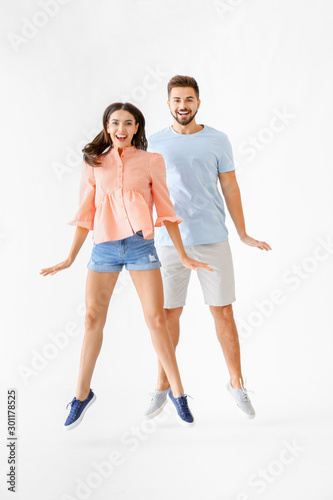 Portrait of jumping young couple on white background