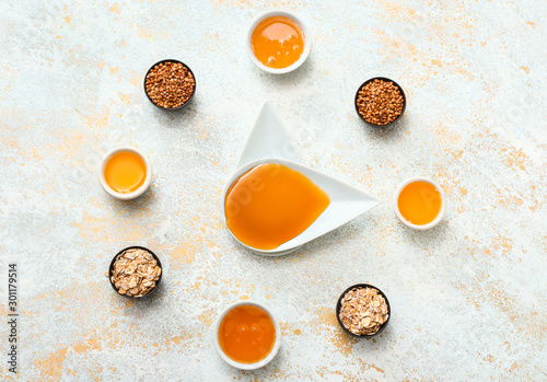 Different tasty honey with cereals on white background