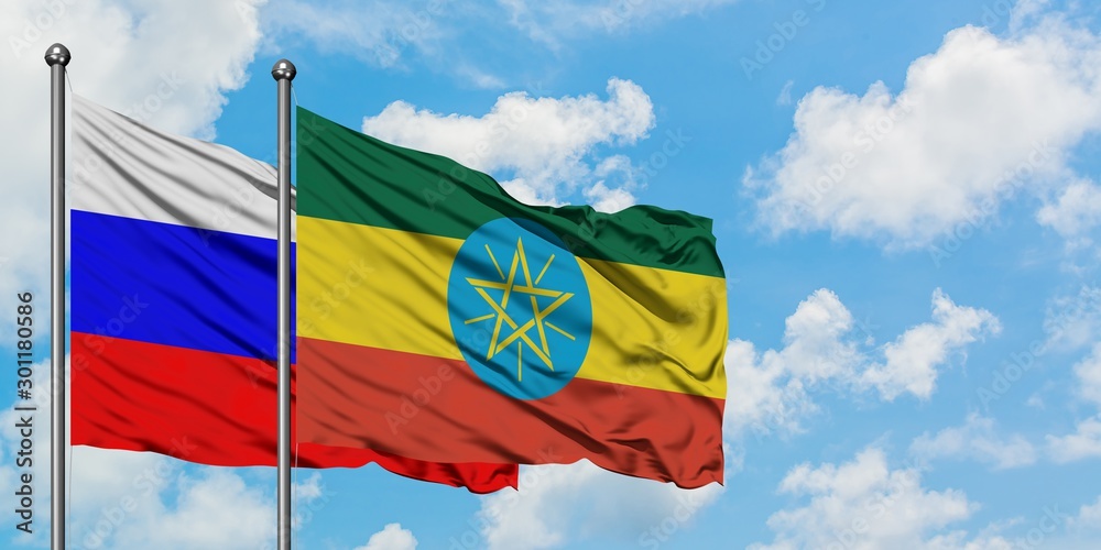 Russia and Ethiopia flag waving in the wind against white cloudy blue sky together. Diplomacy concept, international relations. Russia and Ethiopia flag waving in the wind against white cloudy blue sky together. Diplomacy concept, international relations.