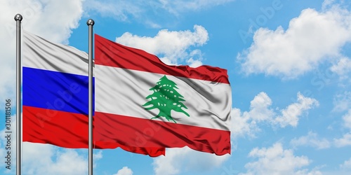 Russia and Lebanon flag waving in the wind against white cloudy blue sky together. Diplomacy concept, international relations.