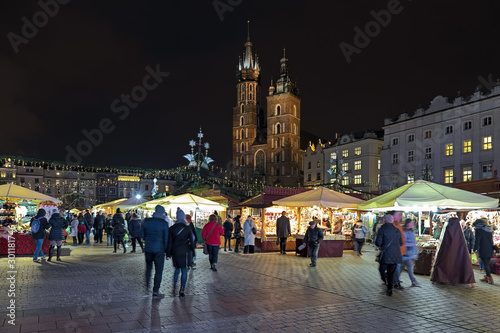 Christmas market at the Main Square of Krakow in front of the St. Mary's Basilica in night, Poland